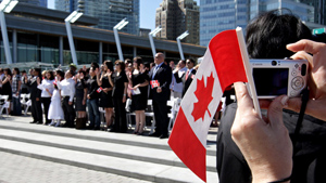 New Canadians take the oath of citizenship during a ceremony as part of Canada Day celebrations. Photo credit : CBCNews.com